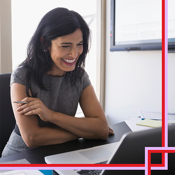 Woman looking at laptop smiling.